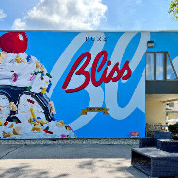 Indulge your sweet tooth with this giant ice cream sundae mural in Attleboro, MA! This vibrant 53' x 22' artwork, commissioned by New England Ice Cream Corporation, is a playful masterpiece that's perfect for selfies and a dose of happiness